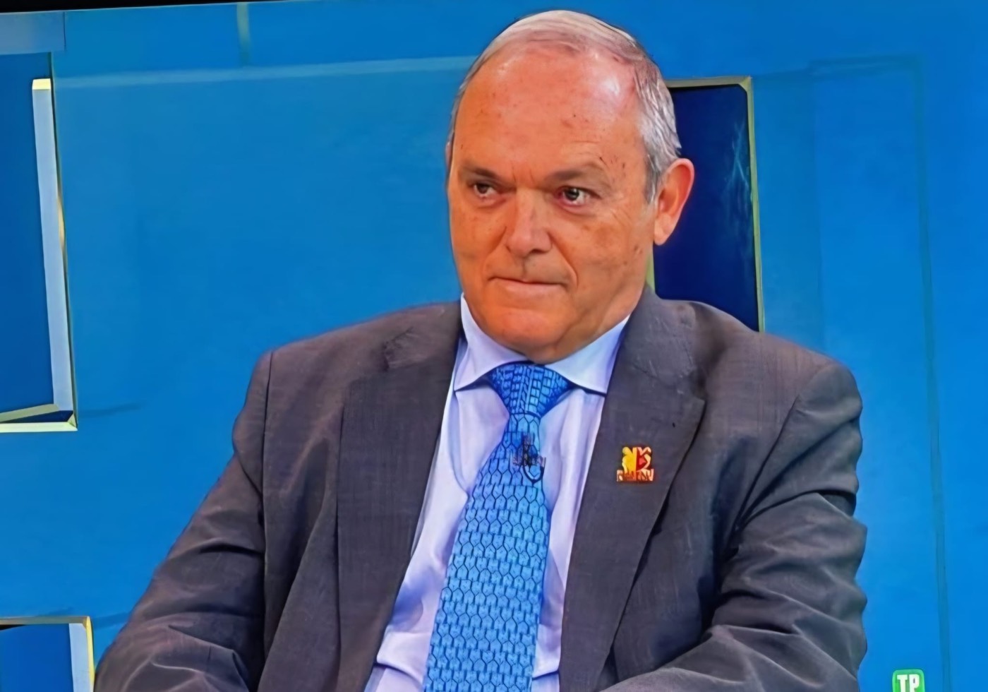 José Manuel Almuzara durante una entrevista de televisión, sentado ante un plató de fondo azul.