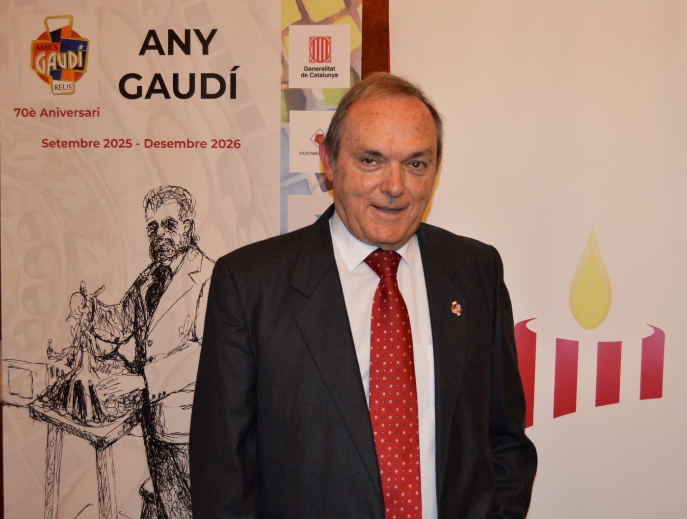 José Manuel Almuzara posa sonriente junto a un cartel del 'Any Gaudí, 70è Aniversari' de la Generalitat de Catalunya.