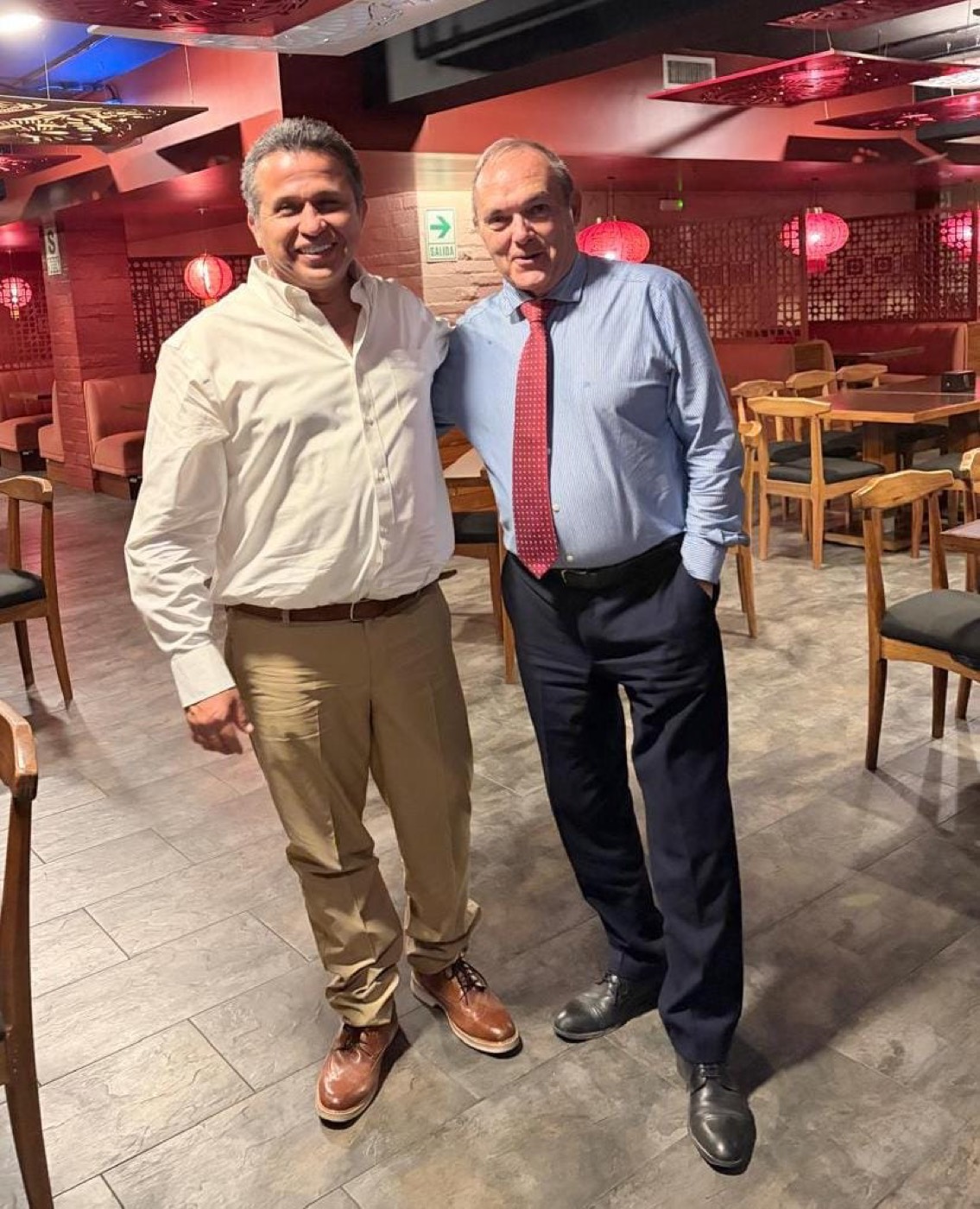 José Manuel Almuzara posa junto a otro hombre en el interior de un restaurante de decoración oriental.